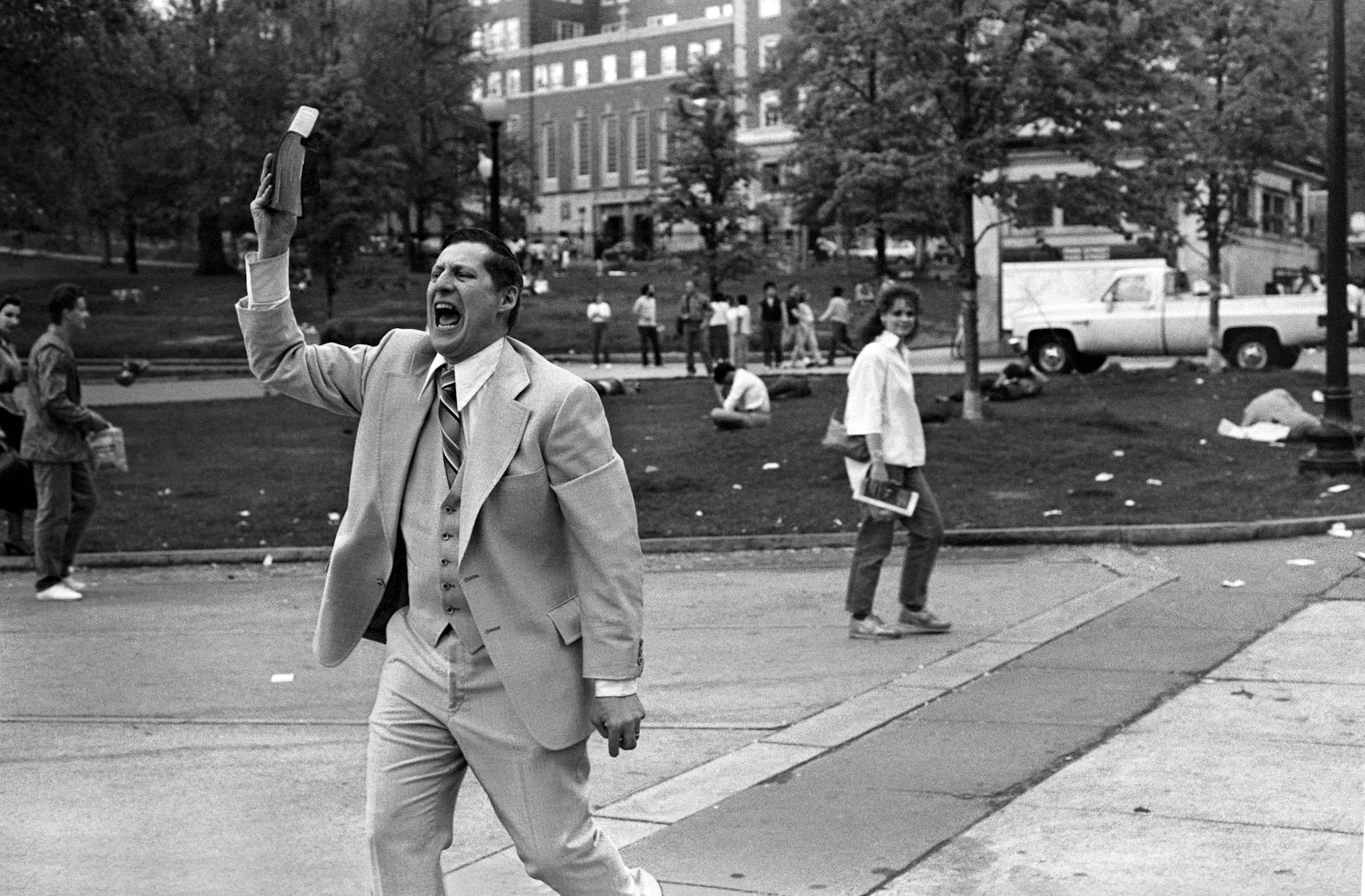 man in white suit standing on street