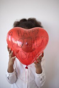 close up shot of a person holding a red balloon