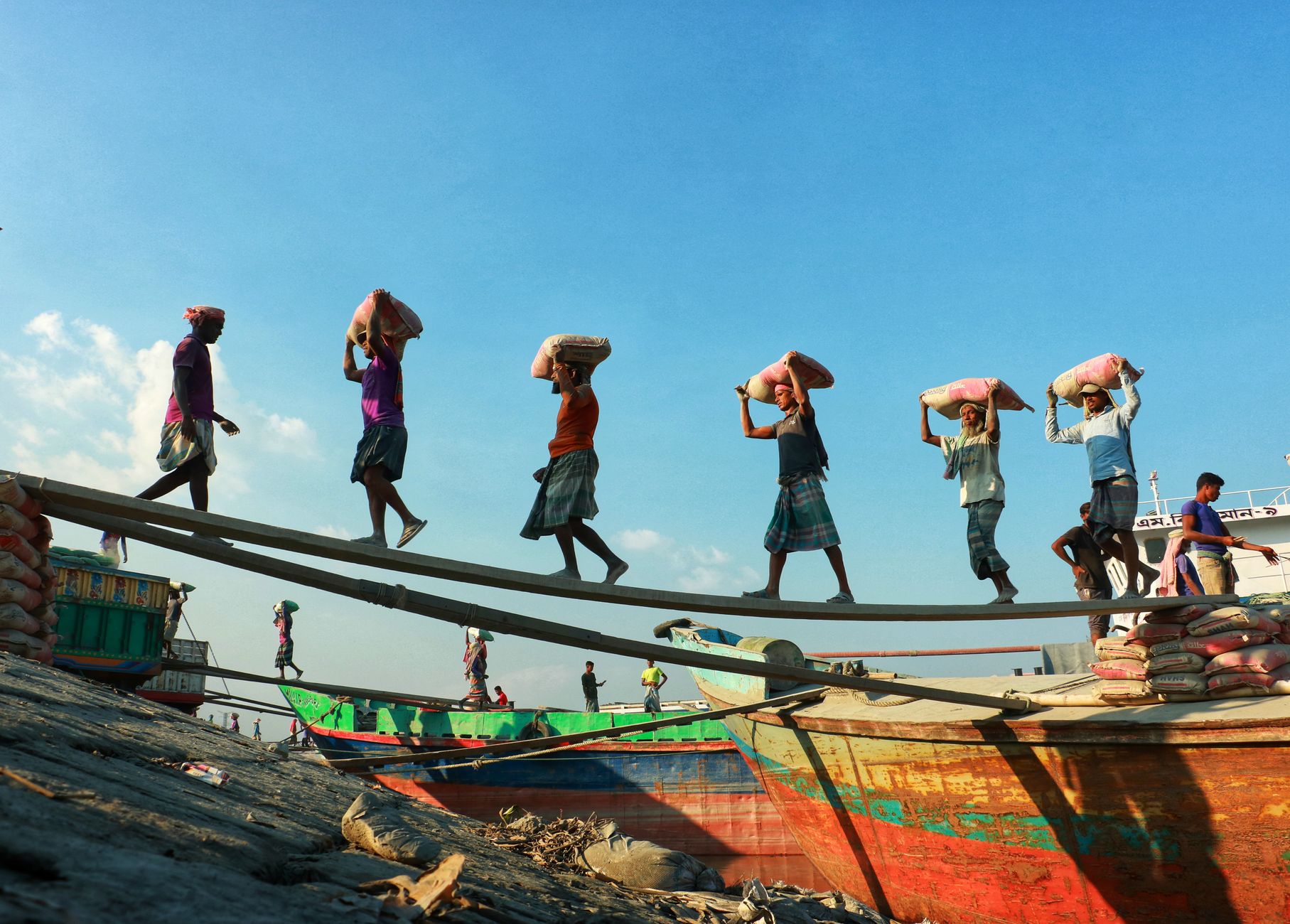 workers carrying bags from boats to shore