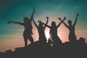 silhouette of four people against sun background