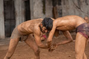 men wrestling on dirt